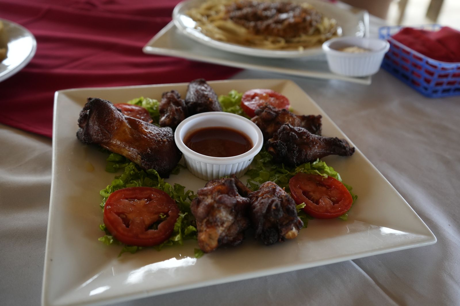 Plato con piezas de pollo asado, ensalada y salsa, servido en el restaurante del hotel.