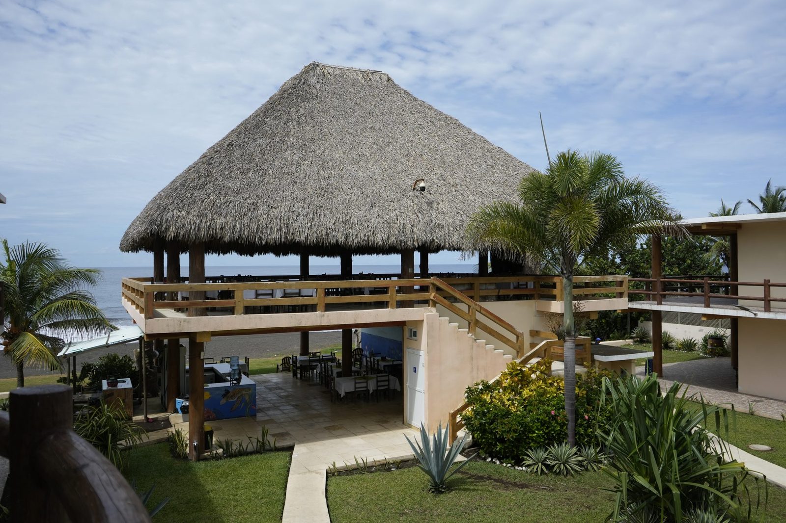 Gran palapa del hotel con el océano Pacífico detrás.
